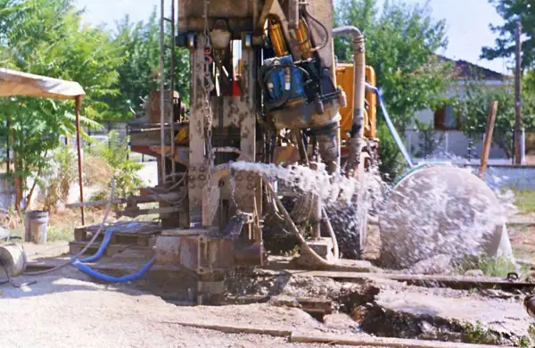 Water spraying from a drilling rig during well development