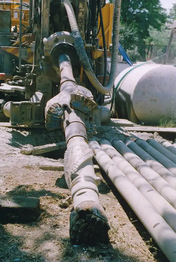 Drill pipes and drill bits laid out at a drilling site